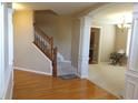 Inviting foyer featuring hardwood floors, staircase, and elegant archway leading to a carpeted living area at 2219 Stone Manor Ct, Avon, IN 46123
