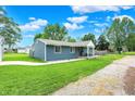 Lovely blue ranch home with green grass, sidewalk and detached garage at 2303 Midway St, Columbus, IN 47201