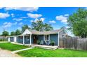 Blue ranch-style home with a well-maintained lawn, inviting front porch, and a detached garage at 2303 Midway St, Columbus, IN 47201