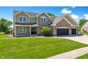 Charming two-story home featuring manicured front lawn and a two-car garage at 28 Hudson Bay Ln, Greenwood, IN 46142