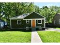 Traditional one-story house with a green facade, and a walkway to the bright orange front door at 3021 Eastern Ave, Indianapolis, IN 46218