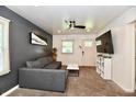 Contemporary living room with gray sofa, mounted TV, ceiling fan and modern decor at 3021 Eastern Ave, Indianapolis, IN 46218