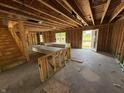Open-concept interior under construction featuring exposed beams, stud walls, and a staircase, revealing the home's framework at 3321 Godby Dr, Sheridan, IN 46069