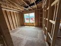 Unfinished room showing exposed wood framing, a window, and a concrete floor, capturing the building phase at 3321 Godby Dr, Sheridan, IN 46069