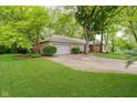 Exterior view of the home and attached garage showing mature trees, well-maintained lawn, and curb appeal at 3698 E 106Th St, Carmel, IN 46033
