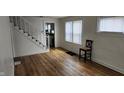 Bright living room features wood-look flooring, a staircase, and ample natural light from the windows at 3848 Spann Ave, Indianapolis, IN 46203
