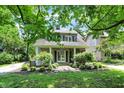Inviting two-story home with a welcoming covered porch, landscaped yard, and classic architectural details at 4527 Central Ave, Indianapolis, IN 46205