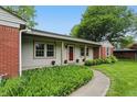 Charming single-story home with a manicured lawn and a combination of brick and light-colored siding at 5129 E 69Th St, Indianapolis, IN 46220