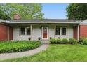 Charming single-story home with a manicured lawn and a combination of brick and light-colored siding at 5129 E 69Th St, Indianapolis, IN 46220