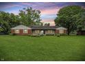 Charming single-story home with a manicured lawn and a combination of brick and light-colored siding at 5129 E 69Th St, Indianapolis, IN 46220