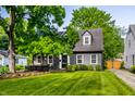 Charming house with a well-maintained lawn, lush tree, and classic architectural details at 5280 N Capitol Ave, Indianapolis, IN 46208