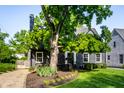 Charming house with a well-maintained lawn, lush tree, and classic architectural details at 5280 N Capitol Ave, Indianapolis, IN 46208