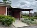 Covered patio area with brick siding, landscaping, and partial view of backyard at 5457 W 900 North, McCordsville, IN 46055