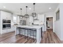 Stylish kitchen with a large island, modern pendant lights, stainless steel appliances, and pristine white cabinetry at 591 Dalton Way, Avon, IN 46123