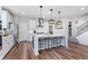 Bright kitchen features a large island, stylish pendant lighting, stainless steel appliances, and hardwood flooring at 591 Dalton Way, Avon, IN 46123