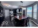 Eat-in kitchen with black cabinets, granite countertops, stainless appliances, wood floors, and large windows at 6155 W Bayfront, McCordsville, IN 46055