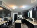Updated kitchen with dark cabinets, stainless steel appliances, and granite countertops at 6155 W Bayfront, McCordsville, IN 46055