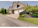 Side view of a two-story home with an attached three-car garage and well-maintained landscaping at 6648 Westminster Dr, Zionsville, IN 46077