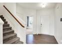 Welcoming foyer with hardwood floors, a staircase, and a front door, leading to a bright and open living space at 6843 Black Cherry Ter, Brownsburg, IN 46112