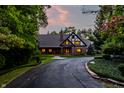 Well-maintained Tudor-style home with manicured landscaping and lit windows at dusk at 7406 N Washington Blvd, Indianapolis, IN 46240