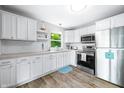 Bright kitchen with stainless steel appliances, white cabinets, and a window view of the backyard at 7595 Heather Dr, Nineveh, IN 46164