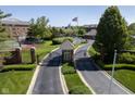 Community gated entrance with manicured landscaping, tennis court, and American flag waving in the breeze at 8751 Jaffa Court East Dr # Apt 32, Indianapolis, IN 46260