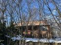 Charming home with wood siding and a quaint front porch, surrounded by bare winter trees and sitting atop a stone foundation at 8803 S Sleepy Hollow Rd, Waldron, IN 46182