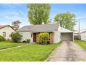 Cozy home with attached garage, green lawn, and mature trees at 916 S Outer Dr, Lebanon, IN 46052