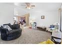 Spacious living room with neutral carpet, a ceiling fan, and a view into an office area, creating a welcoming atmosphere at 1000 E Willard St, Muncie, IN 47302
