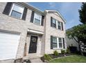 Charming two-story home featuring a brick facade, black door and manicured lawn at 10266 Hatherley Way, Fishers, IN 46037