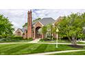 Charming front exterior of brick home with lush landscaping and neatly trimmed lawn at 10554 Hyde Park, Carmel, IN 46032