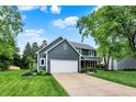 Two-story home with covered porch, two car garage, driveway, beautiful lawn, and mature trees at 10906 Camden Ct, Fishers, IN 46038