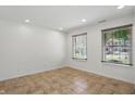 Neutral room showcases tile flooring, two windows with blinds, and recessed lighting at 1111 Cavendish Dr, Carmel, IN 46032