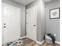 Neutral-toned entryway featuring two white doors, wood-look floors, and decorative wall art at 12328 Slate Dr, Fishers, IN 46037