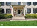 Inviting front porch with rocking chairs, decorative wreath, and manicured landscaping at 13868 Broad Mdw, Carmel, IN 46032