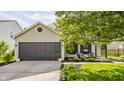 Home featuring a garage and inviting front yard with dark shutters and chairs at 14291 Holly Berry Cir, Fishers, IN 46038