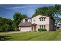 Beautiful two-story house showcasing a blend of brick and siding, an attached garage, and lush greenery at 16226 Montrose Ln, Westfield, IN 46074