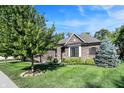 Attractive single-story brick home featuring beautiful landscaping and a well-maintained green lawn on a sunny day at 16890 Catkins Ct, Westfield, IN 46074