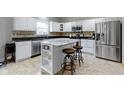 Bright kitchen with white cabinetry, granite countertops, stainless steel appliances, and a center island with barstool seating at 18711 Crestline Ct, Noblesville, IN 46060