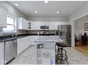 Well-lit kitchen featuring white cabinets, an island with seating, and stainless steel appliances at 18711 Crestline Ct, Noblesville, IN 46060