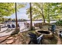 Backyard lake view with a stone firepit and a wooden deck featuring patio furniture for outdoor relaxation at 1940 Stringtown Pike, Cicero, IN 46034