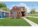 Beautiful two-story home with a modern design, a mix of wood, grey, and black finishes, a deck, and a well-kept lawn at 2302 S Pennsylvania St, Indianapolis, IN 46225