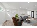 A stylish living room featuring a modern brown chair, a grey couch, hardwood floors, and ample natural light at 2302 S Pennsylvania St, Indianapolis, IN 46225