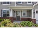 Inviting front porch with brick facade, white columns, and a stylish front door at 2780 Cormorant Dr, Greenwood, IN 46143