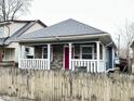 Charming home featuring a stone facade, inviting front porch with white railings and a vibrant red front door at 309 N Forest Ave, Indianapolis, IN 46201