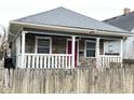 Charming home featuring a stone facade, inviting front porch with white railings and a vibrant red front door at 309 N Forest Ave, Indianapolis, IN 46201