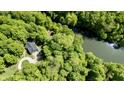 Beautiful aerial showcasing a charming home nestled in dense woods, with a nearby stream at 3273 Bailey Dr, Morgantown, IN 46160