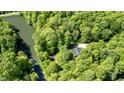 Stunning aerial view of a home located between a lush forest, a calm pond, and a creek at 3273 Bailey Dr, Morgantown, IN 46160