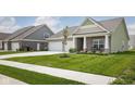 Charming single-Gathering home featuring a well-manicured lawn, a two-car garage, and a welcoming front porch area at 3622 S Setting Sun Ln, New Palestine, IN 46163