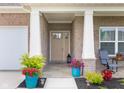 Charming covered front porch area featuring decorative planters and a seating area for relaxation at 3622 S Setting Sun Ln, New Palestine, IN 46163